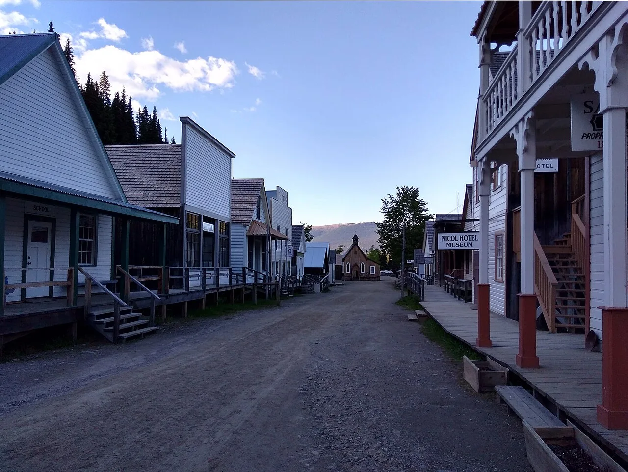 Photograph of Main Street in Barkerville Historic Town, British Columbia, a dirt main street lined with 1860s wooden buildings and boardwalks