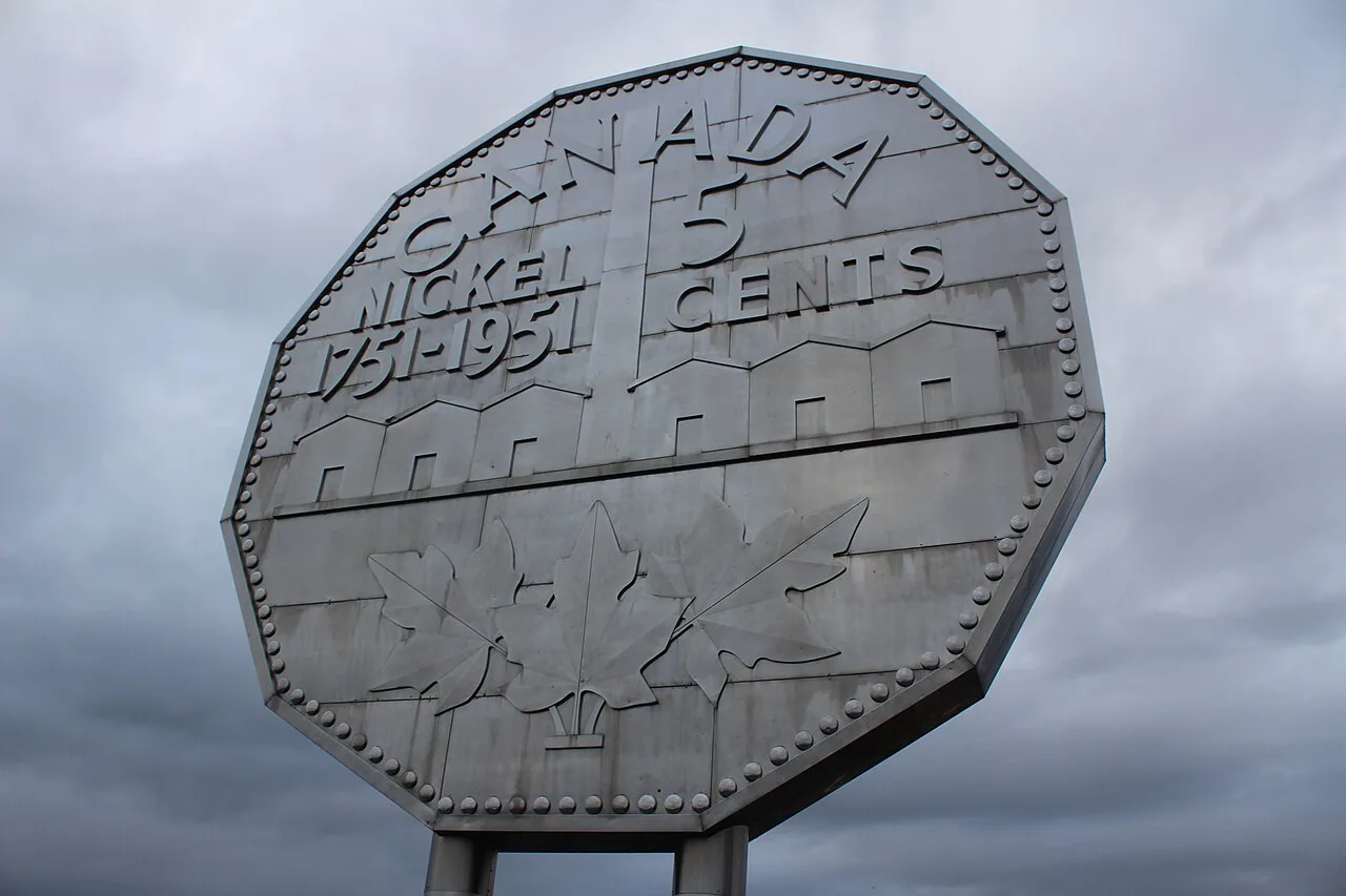 Photograph of the Big Nickel in Sudbury, Ontario, a giant stainless-steel replica of a 1951 Canadian five-cent coin against a cloudy sky